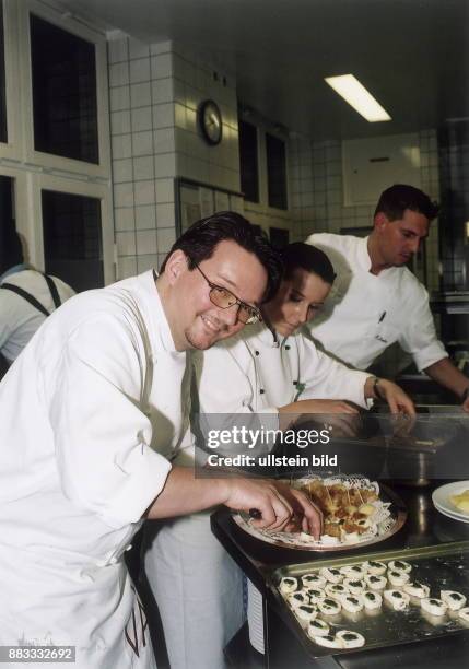 Koch, D Chefkoch im Restaurant VAU in Berlin in der Küche beim Zubereiten von kalten Platten mit seinen Kollegen
