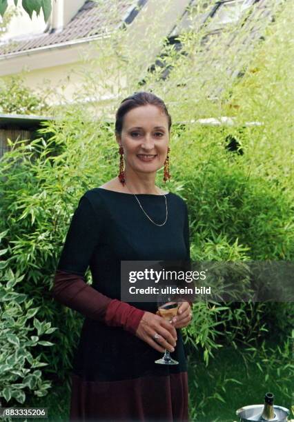 Schauspielerin, Sängerin, D steht mit Sektglas in einem Garten - Juni 2000