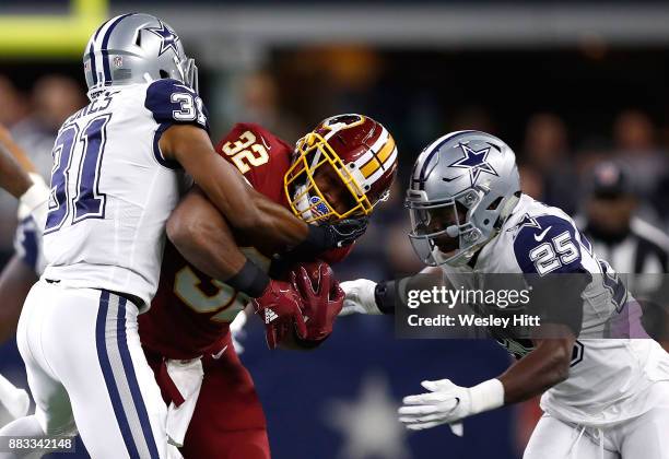 Samaje Perine of the Washington Redskins is stopped by Byron Jones and Xavier Woods of the Dallas Cowboys in the first quarter of a football game at...