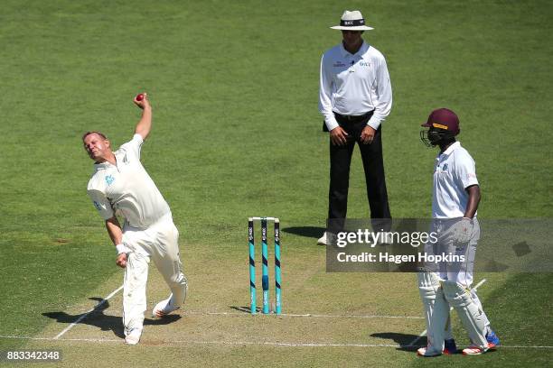 Neil Wagner of New Zealand bowls while umpire Rod Tucker of Australia and Kemar Roach of the West Indies look on during day one of the Test match...