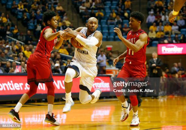 Jevon Carter of the West Virginia Mountaineers handles the ball between Diandre Wilson and Shyquan Gibbs of the N.J.I.T Highlanders at the WVU...