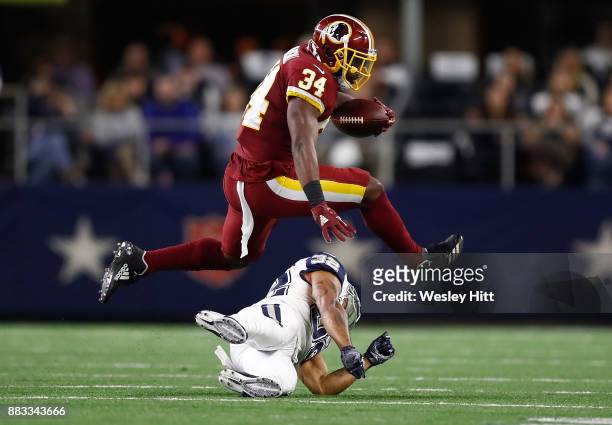 Byron Marshall of the Washington Redskins leaps over Orlando Scandrick of the Dallas Cowboys on a run in the first quarter of a football game at AT&T...