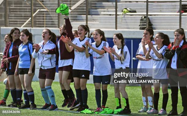 Photo taken on September 14 shows refugee Sarah Glaoo aged 17, cheering fellow players with teammates during a football match organised by Football...