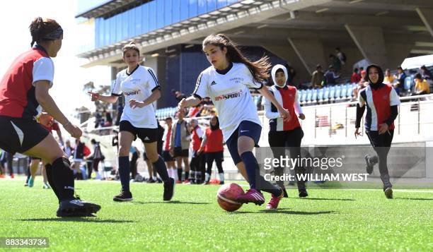 Photo taken on September 14 shows refugee Sarah Glaoo aged 17 in action during a football match organised by Football United, a programme helping...
