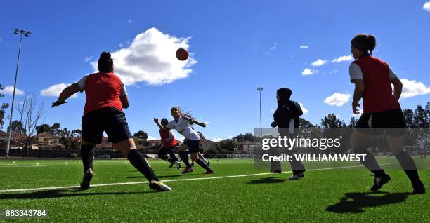 Photo taken on September 14 shows refugee Sarah Glaoo aged 17 heading the ball during a football match organised by Football United, a programme...