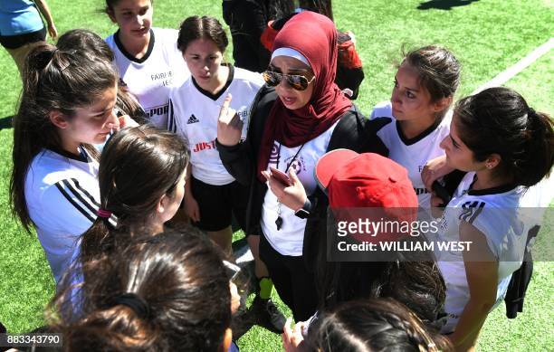 Photo taken on September 14 shows a coach talking to her players during a football match organised by Football United, a programme helping refugees...