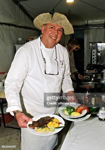 Koch, Gastronom, D - auf dem Gauklerfest am Opernpalais, Unter den Linden, in Berlin - mit zwei Tellern, gefüllt mit Speisen, in den Händen