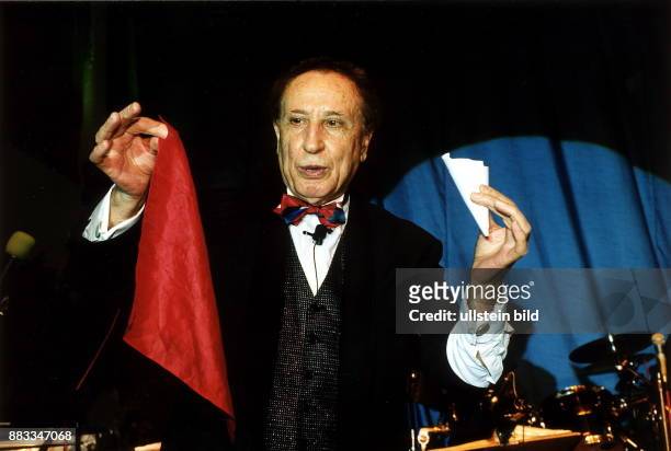 Zauberer; UdSSR - Inhaber eines Zaubertheaters in Berlin - während einem Zaubertrick mit einem Blatt Papier und einem roten Tuch - Oktober 1999