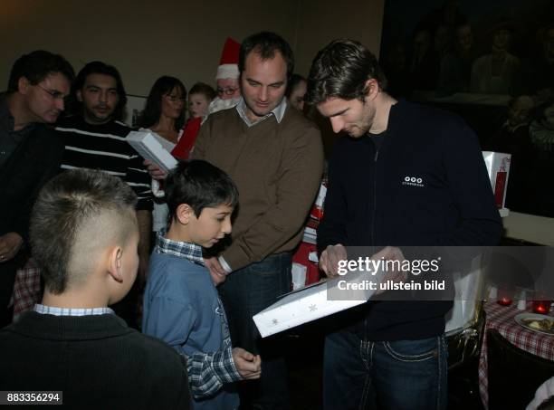 Friedrich, Arne - Fussball, Abwehrspieler, Hertha BSC Berlin, D - mit Dick van Burik bei einer Charity Weihnachtsfeier im Ganymed, verteilen...