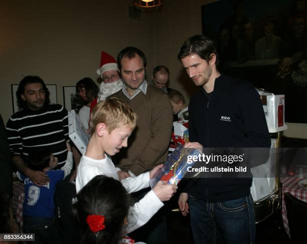 Friedrich, Arne - Fussball, Abwehrspieler, Hertha BSC Berlin, D - mit Dick van Burik bei einer Charity Weihnachtsfeier im Ganymed, verteilen...