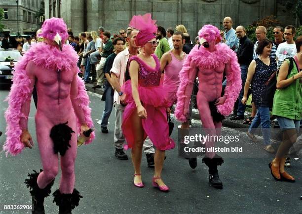 Teilnehmer der Homosexuellen - Parade in Pink: zwei Männer in einem Vogel - Kostüm mit Maske und eine Frau in einem Kleid mit Tüll und Pailletten und...