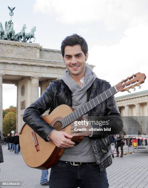 Der Musiker Milos Karadaglic mit seiner Gitarre aufgenommen vor dem Brandenburger-Tor in Berlin