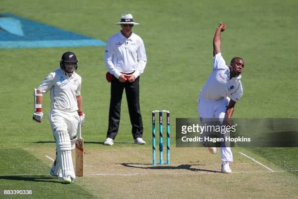 Miguel Cummins of the West Indies bowls while umpire Rod Tucker of Australia and Tom Latham of New Zealand look on during day one of the Test match...