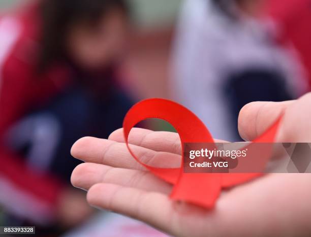 Student of Chaohu No.2 Middle School shows handmade red ribbons on November 30, 2017 in Chaohu, Anhui Province of China. Chaohu No.2 Middle School...