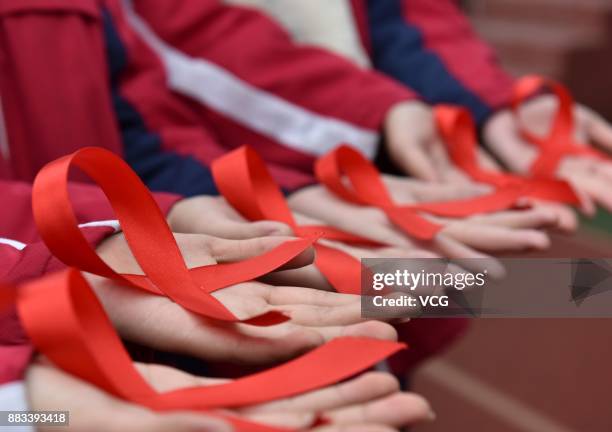 Students of Chaohu No.2 Middle School show handmade red ribbons on November 30, 2017 in Chaohu, Anhui Province of China. Chaohu No.2 Middle School...