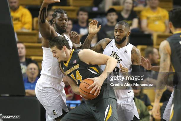 Reed Nikko of the Missouri Tigers drives to the basket against Chad Brown and Dayon Griffin of the UCF Knights during a NCAA basketball game at the...