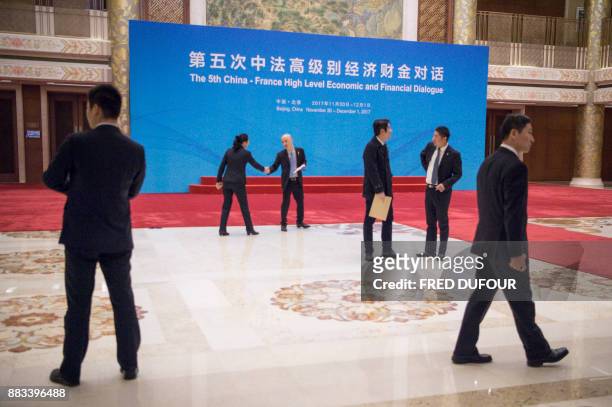 Security guards and delegates wait for the arrival of Chinese Vice Premier Ma Kai and French Economic Minister Bruno Le Maire at the High Level...