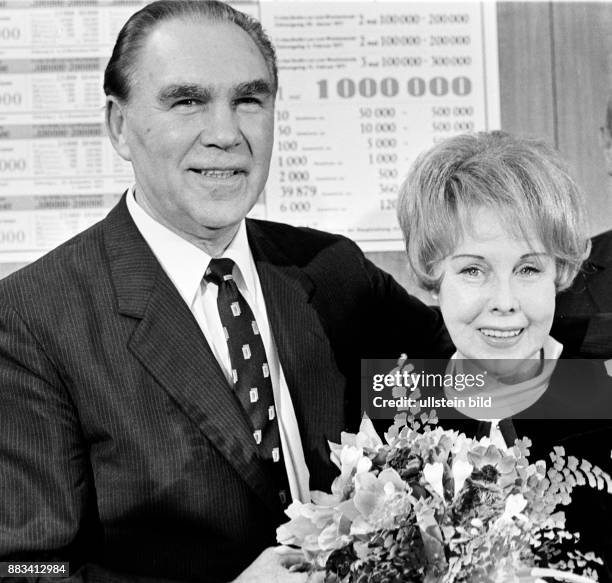 Der ehemalige Boxprofi und Unternehmer Max Schmeling mit seiner Frau, der Schauspielerin Anny Ondra. Sie hat einen Blumenstrauß in der Hand.