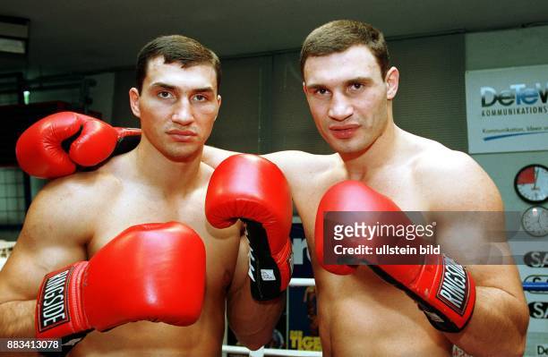 Die Brüder Wladimir und Vitali Klitschko, Boxer aus der Ukraine. Rote Boxhandschuhe, nackter Oberkörper .