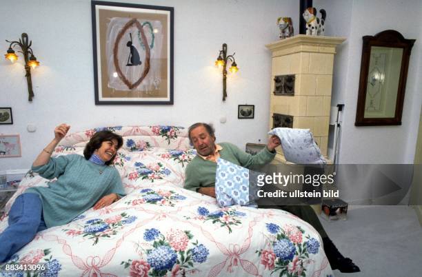 Der Theater- und Filmschauspieler Hans Clarin mit seiner Ehefrau Christa. Sie liegen beide auf dem Bett in ihrem Schlafzimmer. Clarin hat ein Kissen...