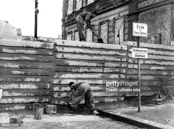 Berlin Mauer : Bernauer Strasse. Baumassnahmen an der Mauer - Ersatz der Mauersteine durch Betonplatten. Grenzsoldaten der NVA bauen unter Bewachung...