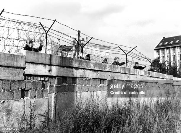 Berlin Mauer Zimmerstrasse Grenzsoldaten der NVA befestigen Stacheldraht auf der Berliner Mauer. 1962