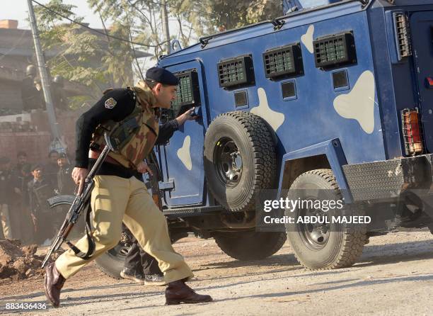 Pakistani security personnel take position outside an Agriculture Training Institute after an attack by Taliban militants in Peshawar on December 1,...