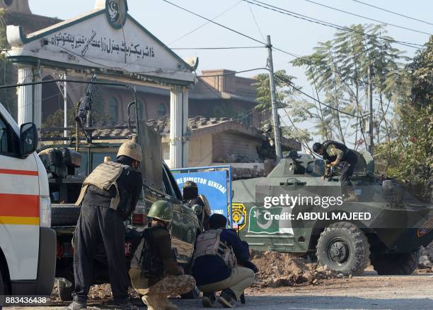 Pakistani security personnel take position outside an Agriculture Training Institute after an attack by Taliban militants in Peshawar on December 1,...