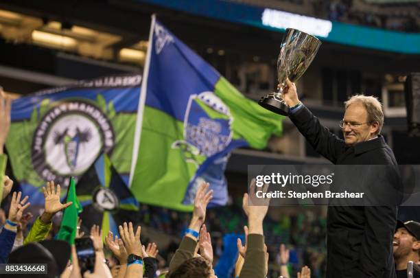 Seattle Sounders head coach Brian Schmetzer hoists the championship trophy after the second leg of the MLS Western Conference Finals against the...