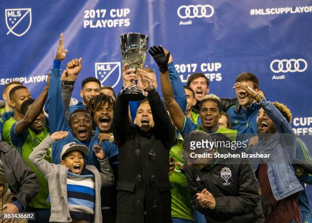 Osvaldo Alonso of the Seattle Sounders hoists the championship trophy as other members of of the Seattle Sounders celebrate after the second leg of...