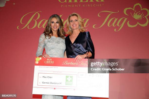 Elizabeth "Liz" Hurley and Maria Furtwaengler with check during the Mon Cheri Barbara Tag at Postpalast on November 30, 2017 in Munich, Germany.