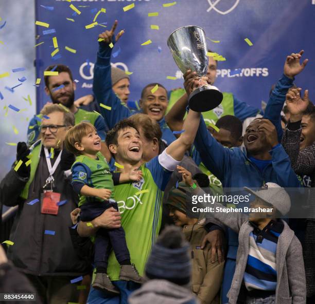 Nicolas Lodeiro of the Seattle Sounders holds up the champsionship trophy and his son while celebrating with other Seattle Sounders after of the...