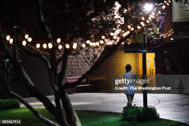 Shae Turner stands by herself and talks on the phone with her father while attending a homecoming dance at Faith Lutheran Middle School and High...