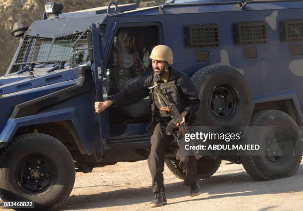 Pakistani police commando escort rescued staff members of an Agriculture Training Institute sit in a armoured vehicle after an attack by Taliban...