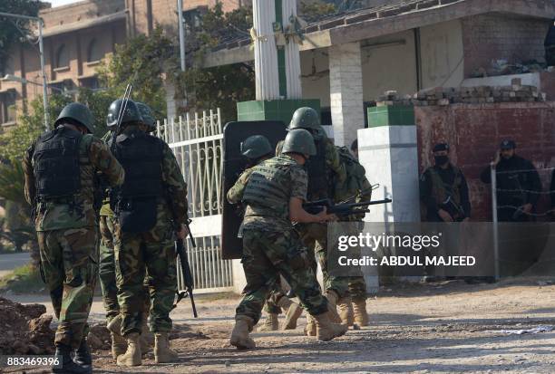 Pakistani soldiers enter an Agriculture Training Institute after an attack by Taliban militants in Peshawar on December 1, 2017. Nine people were...