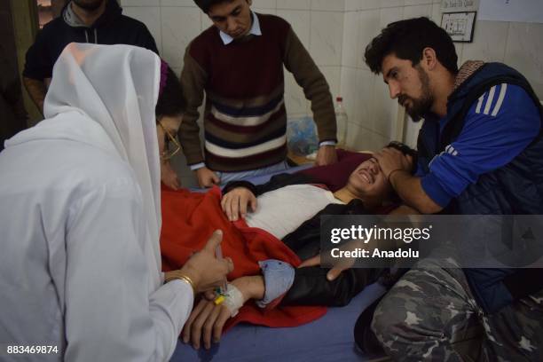 Pakistani nurse tends an injured victim at a hospital following an attack on Peshawar Agricultural Training Institute by Taliban militants, in the...