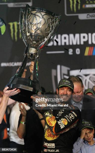 Martin Truex Jr. Gets help in hoisting the Monster Energy NASCAR Cup Series Championship after winning both Ford EcoBoost 400 and the series...