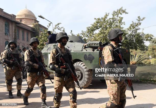 Pakistani soldiers walk at the premises of an Agriculture Training Institute after an attack by Taliban militants in Peshawar on December 1, 2017....