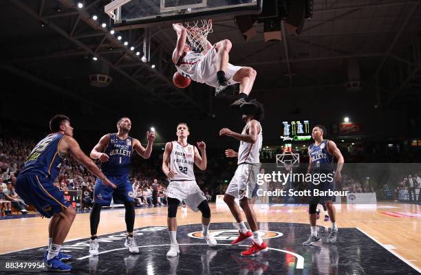 Mitchell Creek of the 36ers hangs from the basket after dunking the ball during the round eight NBL match between the Adelaide 36ers and the Brisbane...