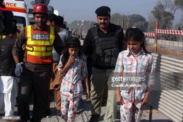Pakistani security forces and rescuers escort girls who were evacuated Peshawar Agricultural Training Institute which was attacked by Taliban...