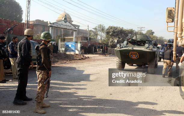 Pakistani security forces are seen outside Peshawar Agricultural Training Institute which was attacked by Taliban militants, in the northwestern city...