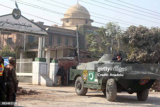 Pakistani security forces and rescuers are seen at the main gate of Peshawar Agricultural Training Institute which was attacked by Taliban militants,...