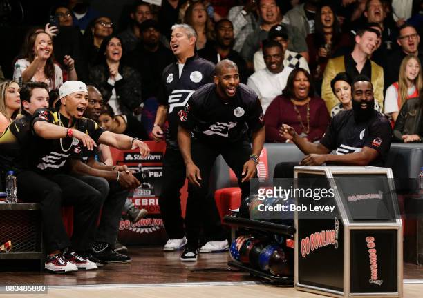 Chris Paul and James Harden watch Trevor Ariza hit a strike as they attends the State Farm Chris Paul PBA Celebrity Invitational at the Bowlero...