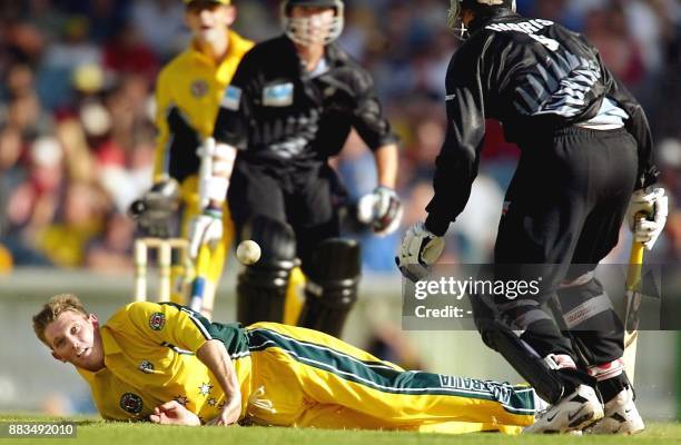 Australian bowler Ian Harvey dives to stop the ball as teammate Adam Gilchrist and New Zealand batsmen James Franklin and Chris Harris look on in...