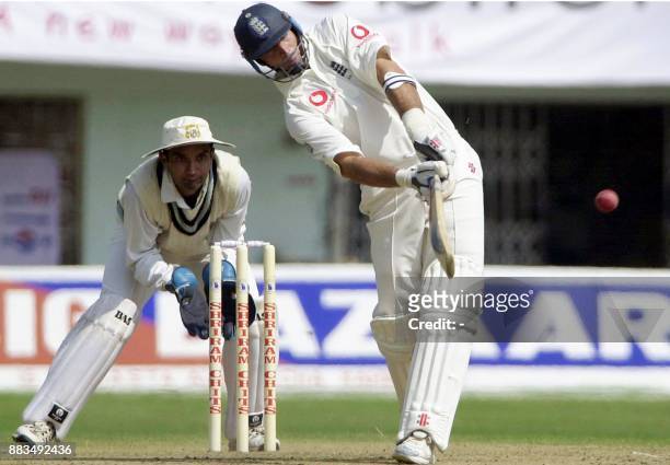England captain Nasser Hussain hits a ball off Indian bowler Sarandeep Singh for a six as Indian wicketkeeper Pankaj Dharmani looks on during the...