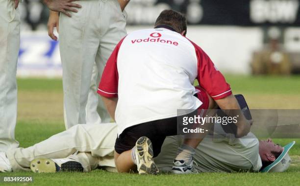English team physio Dean Conway treats Michael Vaughn for a groin injury received while fielding a shot from India's Board President's XI batsman...