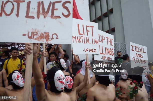 Members of the Alpha Phi Omega display placards as they run around naked in the Arts and Sciences building in the traditional "Oblation Run" to...