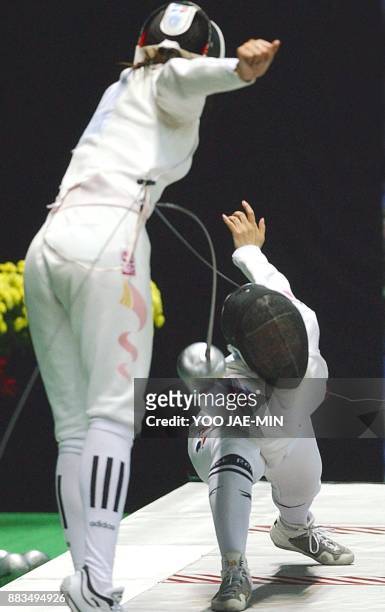 Kim Mi Jung of South Korea attacks Li Na of China during the fencing women's epee team final at the 14th Asian Games in Busan 04 October 2002. The...