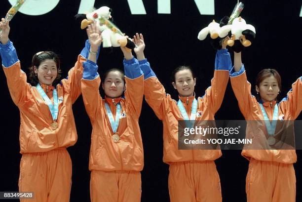 South Korean champion women fencing team from left Kim Hee Jeong, Lee Keum Nam, Hyun Hee and Kim Mi Jung wave with their gold medals after the awards...