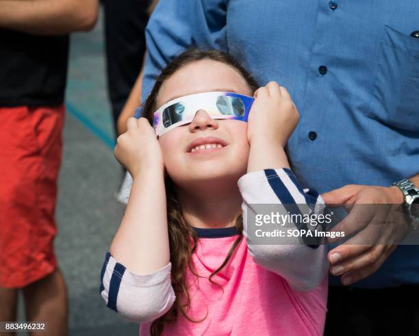 Girl watching for the solar eclipse as seen in Times Square in New York City.